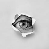 Eye looking through tear in paper